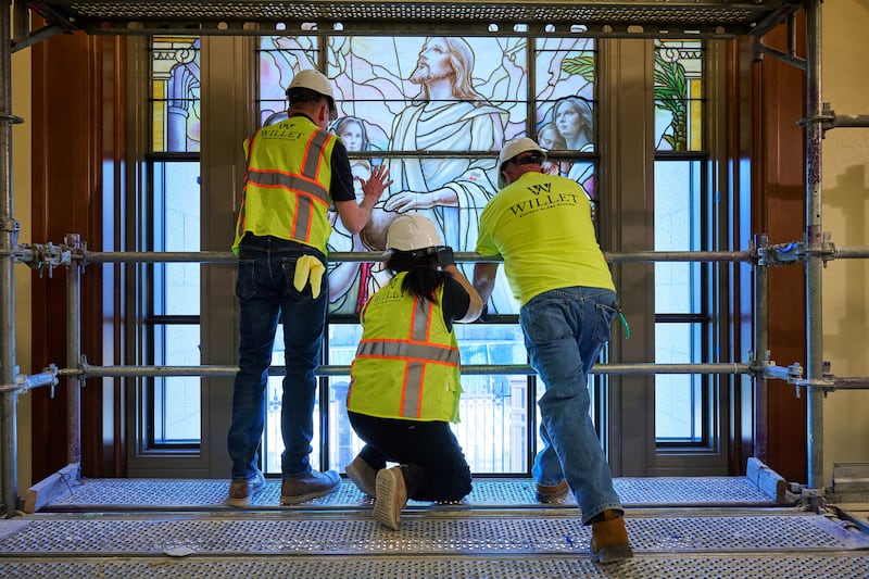 As equipes colocam meticulosamente os painéis de vidro artístico nos edifícios da entrada norte na Praça do Templo em Salt Lake City na quarta-feira, 11 de março de 2026.