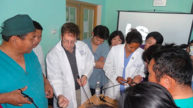 Dr. Raymond R. Price, segundo da esquerda, mostra instrumentos laparoscópicos a cirurgiões na Mongólia.