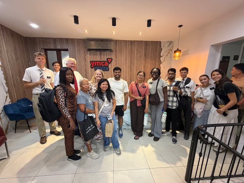 Voluntários adultos jovens de A Igreja de Jesus Cristo dos Santos dos Últimos Dias se reúnem com representantes da YMCA Malta após uma noite de serviço com crianças e famílias em um abrigo para famílias da YMCA Malta em Malta em 1º de agosto de 2026.