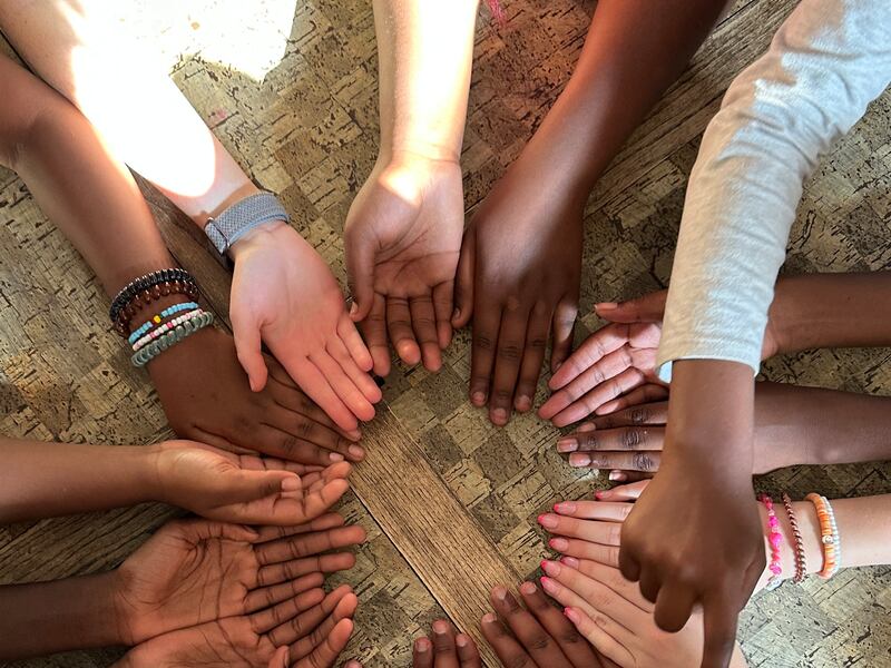 16 mãos são mostradas em um círculo durante o acampamento das moças do Ramo Treasure Valley (Swahili) em Boise, Idaho, 5 de junho de 2025.