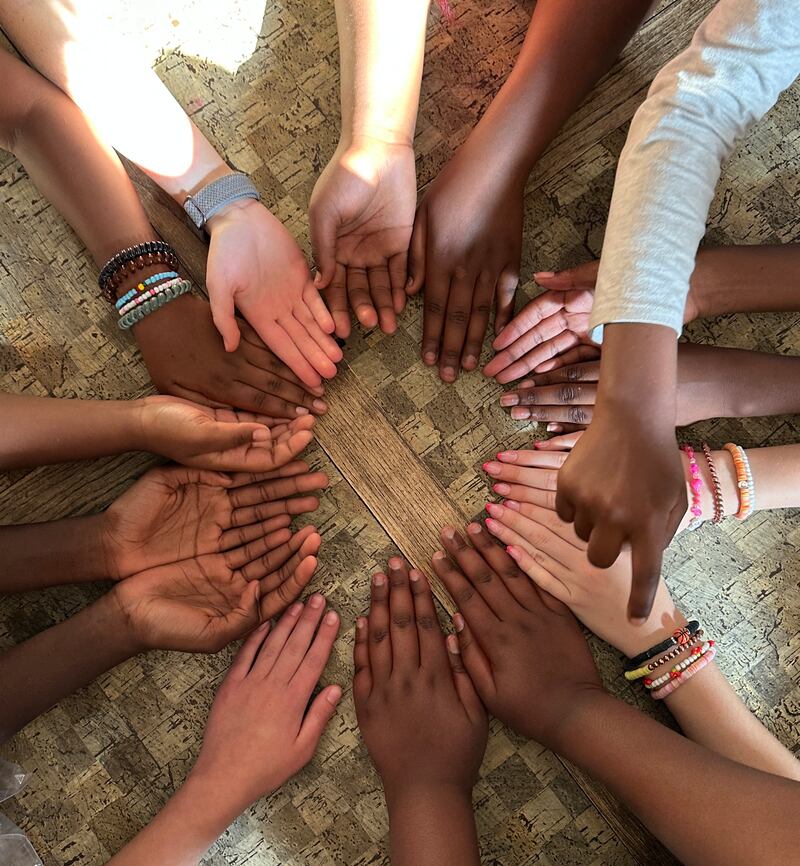 16 mãos são mostradas em círculo durante o acampamento de meninas da ala Treasure Valley (Swahili) em Boise, Idaho, em 5 de junho de 2025.