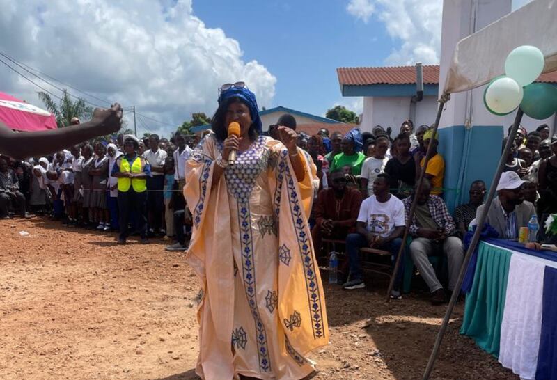 Fatmata Bintu Bockarie discursa para o público de Moriba Town na cerimônia de entrega da nova instalação de saúde comunitária em 11 de outubro de 2025, Serra Leoa.