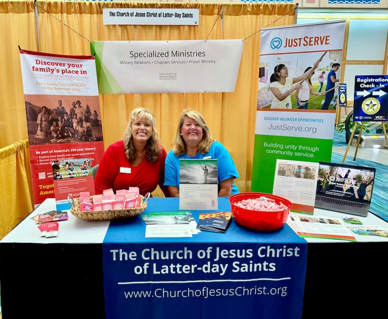 Jennifer Samuels e Kim Fredrick sentam no estande da Igreja na feira de saúde e bem-estar durante os Jogos da Idade de Ouro dos Veteranos Nacionais de 2026 em Tampa, Flórida, em 27 de junho.