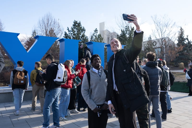 Estudantes da BYU–Idaho tiram selfies com o novo monumento em letras de bloco BYUI inaugurado no campus em 10 de dezembro de 2024.