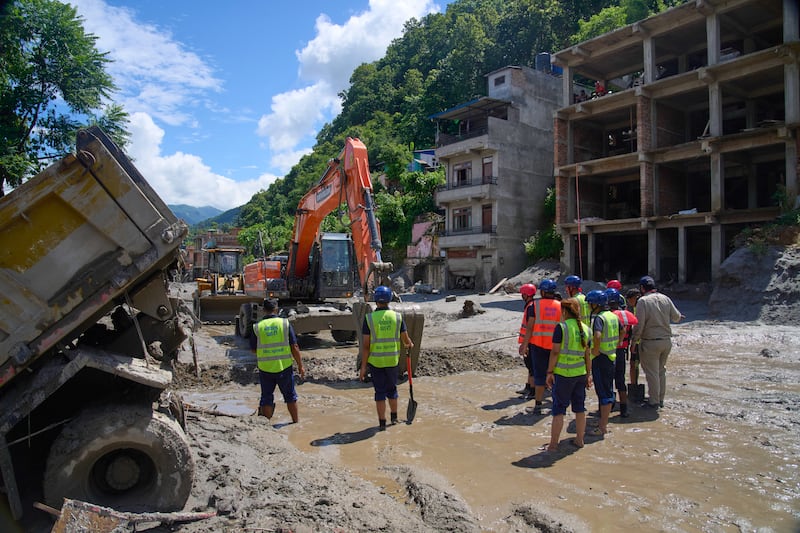 Equipamentos de terraplenagem removem os escombros das enchentes repentinas no distrito de Nuwakot, no Nepal, quinta-feira, 27 de agosto de 2026.