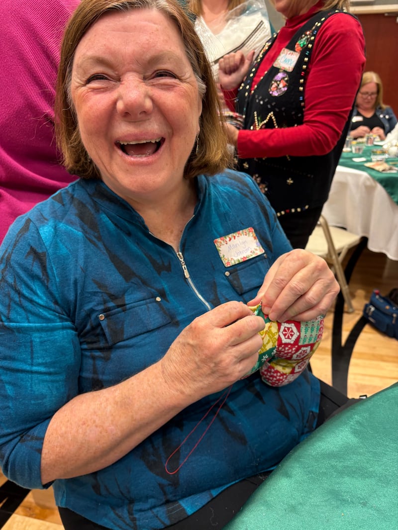 Um membro da Estaca Round Rock Texas enche e costura um travesseiro em forma de coração para crianças em recuperação de cirurgia cardiovascular durante o almoço anual Silver Belles em Cedar Park, Texas, 3 de dezembro de 2025.