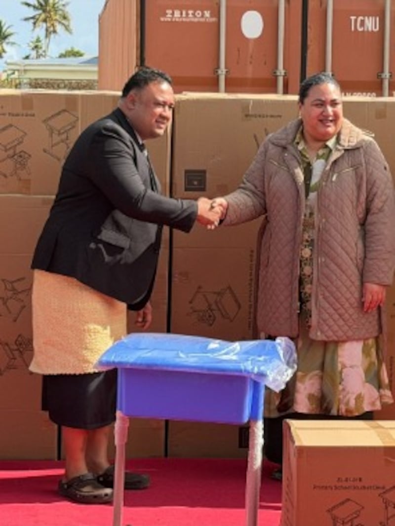 Um presidente de estaca apresenta uma doação de carteiras e cadeiras escolares à Sua Alteza Real Princesa Herdeira de Tonga Sinaitakala Tuku'aho em ʻApi Mataka, Tonga, 16 de julho de 2026.