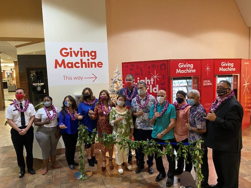 Funcionários de organizações sem fins lucrativos, do governo e da Igreja ajudam no ritual de desamarração de um colar havaiano na cerimônia de abertura das Máquinas de Doações no Pearlridge Center de Aiea, em Honolulu, Havaí, no dia 20 de novembro de 2021. Os presentes incluem Bennette Misalucha, membro da Igreja e senadora estadual, quinta a partir da esquerda; Jaime Green, esposa de Josh Green, vice-governador do Havaí, ao centro na frente; Mufi Hannemann, ao centro atrás; Élder Voi Taeoalii,…