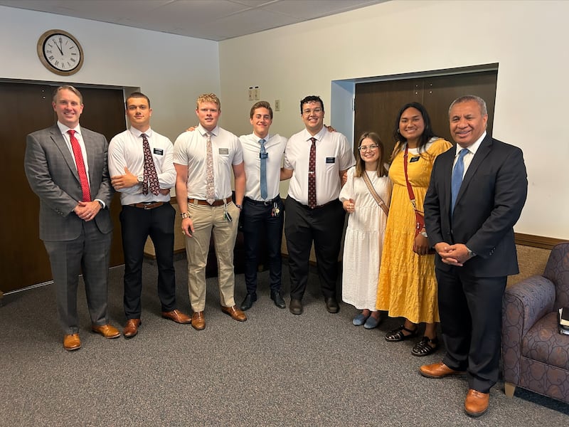 Élder Vaiangina Sikahema, à direita, e o presidente Grant H. Willis, presidente da Estaca Silver Springs Maryland, à esquerda, posam para uma foto com a síster Sela Kata e a síster Lily Doyle, e outros missionários da Missão Washington D.C. Norte, em Silver Springs, Maryland, em maio de 2023.