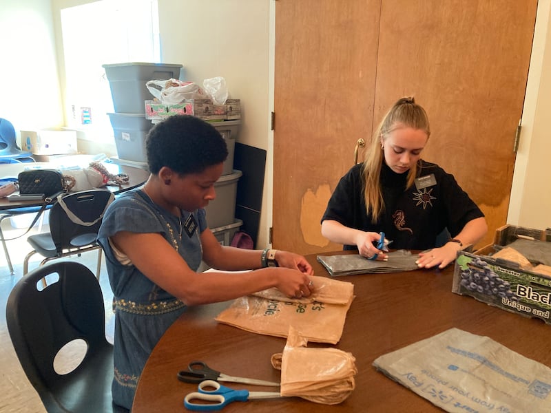 Síster Monica Johnson, à esquerda, e a então síster Chloe Spencer, cortam sacolas de compras para serem tecidas em colchonetes para os sem-teto. Elas estavam servindo no Eastern Hills Baptist Homeless Sleeping Mat Ministry na Igreja Metodista Global Dalraida em Montgomery, Alabama.