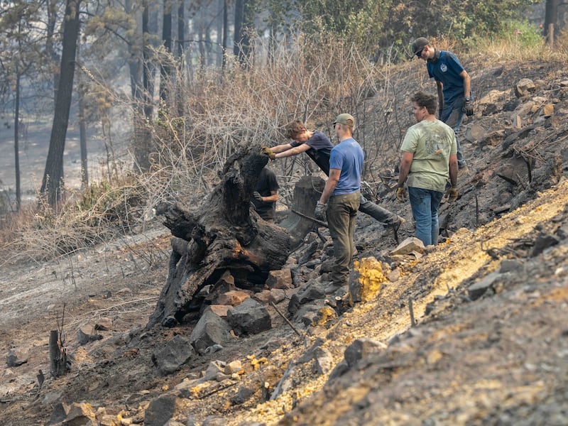 Jovens e líderes da Estaca Mount Spokane de Spokane Washington ajudam a remover detritos de um bairro danificado por incêndios florestais em Spokane, Washington, na segunda-feira, 3 de agosto de 2026.