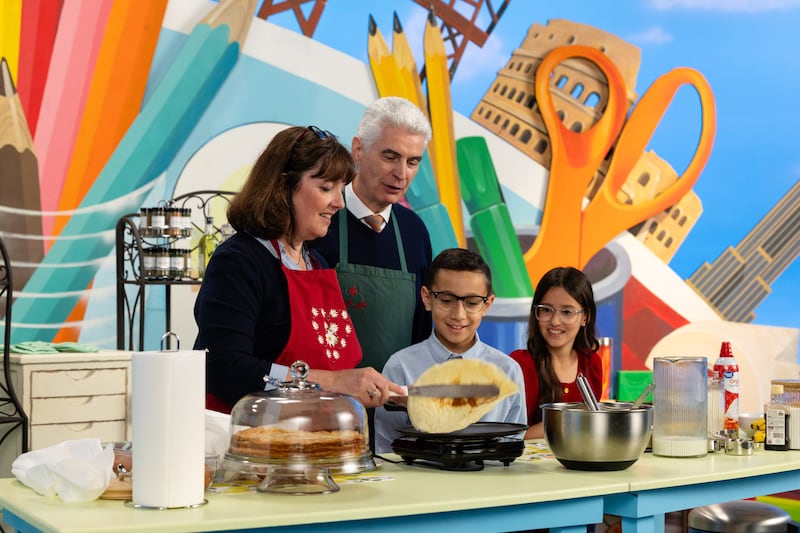 Élder Gérald Caussé e Irmã Valérie Caussé fazem crepes com dois jovens apresentadores durante a transmissão Amigo para Amigo de setembro de 2026.
