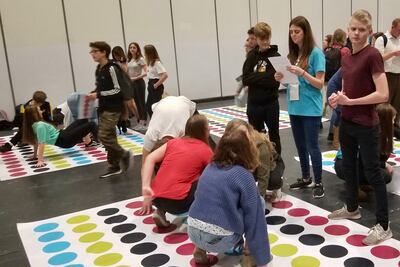Jovens participam de jogo de Twister com tema sobre história da família na atividade de descoberta da RootsTech Londres no dia 26 de outubro, 2019.