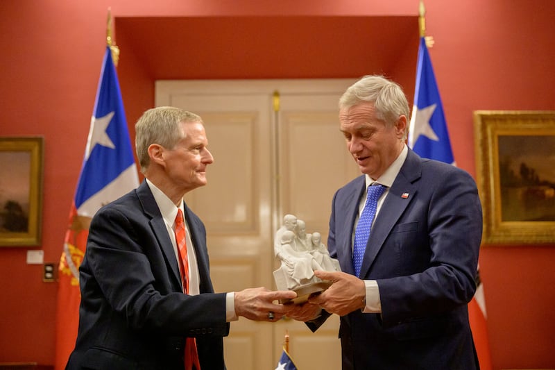 Elder David A. Bednar do Quórum dos Doze Apóstolos de A Igreja de Jesus Cristo dos Santos dos Últimos Dias dá ao Presidente chileno José Antonio Kast uma estátua de uma família.