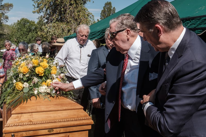 Élder Jeffrey R. Holland, do Quórum dos Doze Apóstolos de A Igreja de Jesus Cristo dos Santos dos Últimos Dias, coloca sua flor da lapela no caixão da irmã Patricia Terry Holland, após a cerimônia em St. George, Utah, no sábado, 29 de julho, 2023.