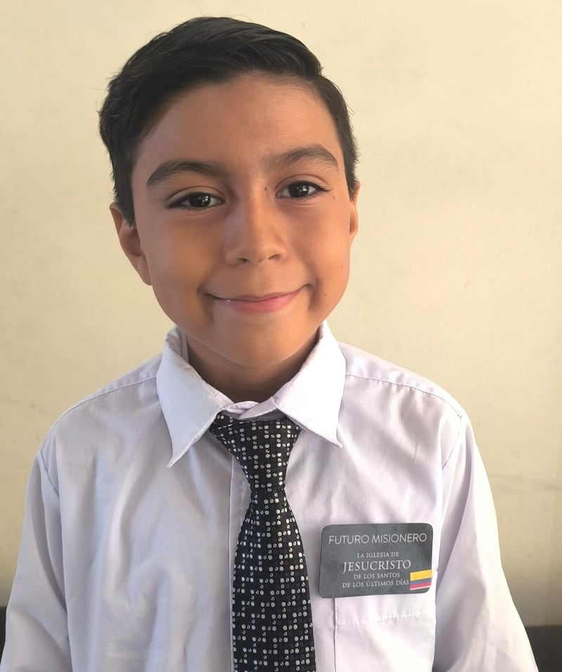 Jorge Mena, 9, sorri para uma foto enquanto usa um crachá "futuro missionário" após a atividade do mini centro de treinamento missionário da Primária da Estaca Samborondón Equador em Guayaquil, Equador, 21 de fevereiro de 2026.