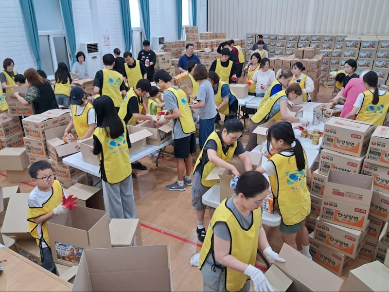 Membros da Estaca Busan Coreia empacotam caixas para idosos em Busan, Coreia do Sul, em 13 de julho de 2026.