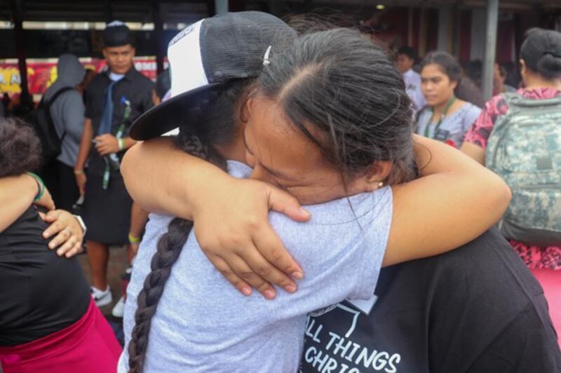 Jovens santos dos últimos dias na Samoa Americana se abraçam, após uma conferência FSY realizada, em julho de 2023.