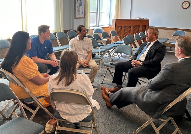 Élder Vaiangina Sikahema, segundo a partir da direita, se junta ao presidente Grant H. Willis, presidente da Estaca Silver Springs Maryland, à direita, e às sísteres Sela Kata e Lily Doyle, em primeiro plano, para ministrar uma aula sobre a Restauração em Silver Springs, Maryland, em maio de 2023.