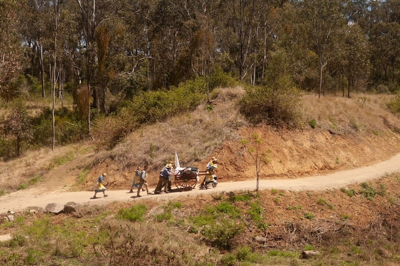Jovens da Estaca Coomera Austrália, no estado de Queensland, puxam carrinhos de mão morro acima durante a primeira reencenação da jornada pioneira de sua estaca, em outubro de 2022.