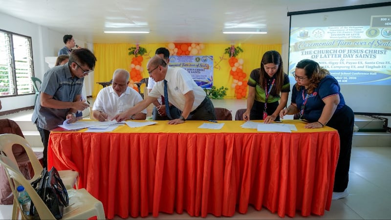 Autoridades assinam documentação para uma doação de poltronas de sala de aula e equipamentos médicos da Igreja em Villaba, Leyte, Filipinas, em 14 de setembro de 2026.