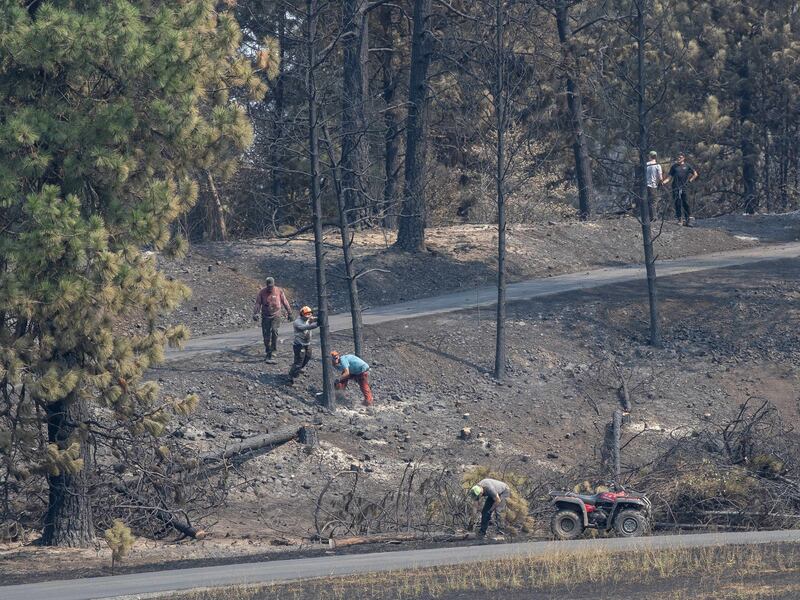 Rapazes e líderes da Estaca Mount Spokane de Spokane, Washington ajudam a limpar escombros de um bairro danificado por incêndios florestais em Spokane, Washington, na segunda-feira, 3 de agosto de 2026.
