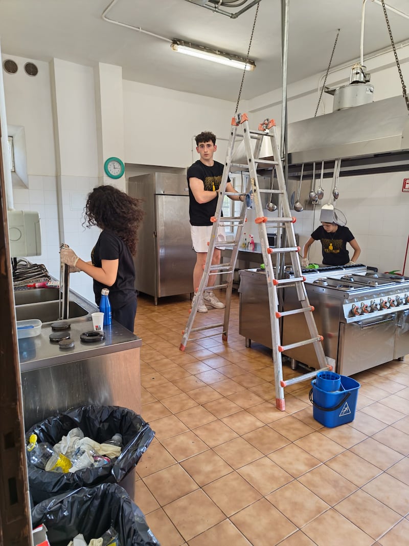 Jovens adultos solteiros de Malta e Sicília limpam a cozinha e equipamentos da Casa Scalabrini 634 em Roma, Itália.