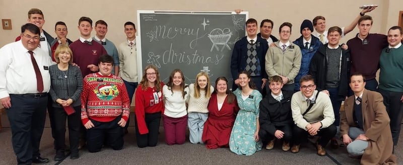 Élder John Bass e síster Denise Bass, à esquerda, servem com missionários e membros da Estaca Pueblo Colorado em Pueblo, Colorado, em 25 de dezembro de 2023.