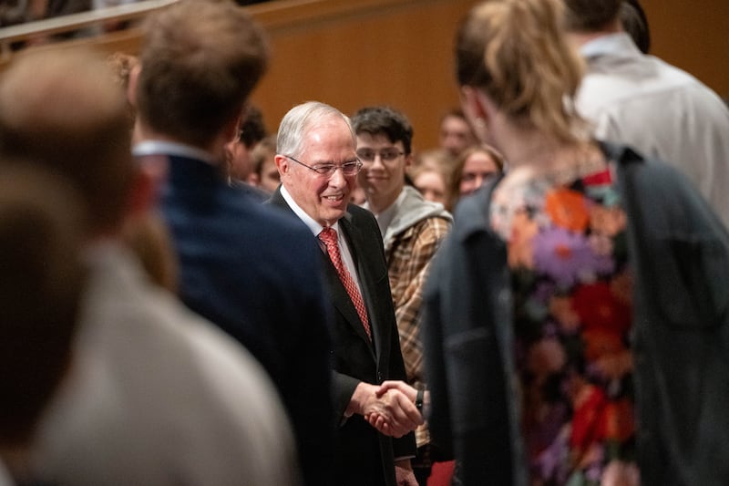 Elder Neil L. Andersen do Quórum dos Doze Apóstolos aperta as mãos com estudantes reunidos no Centro BYU–I durante o devocional no domingo, 22 de fevereiro de 2026, em Rexburg, Idaho.