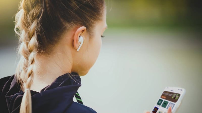 Uma mulher usa fones de ouvido para ouvir música. Um novo recurso foi adicionado ao aplicativo Biblioteca do Evangelho em outubro de 2025 que permite aos usuários criar e compartilhar playlists.