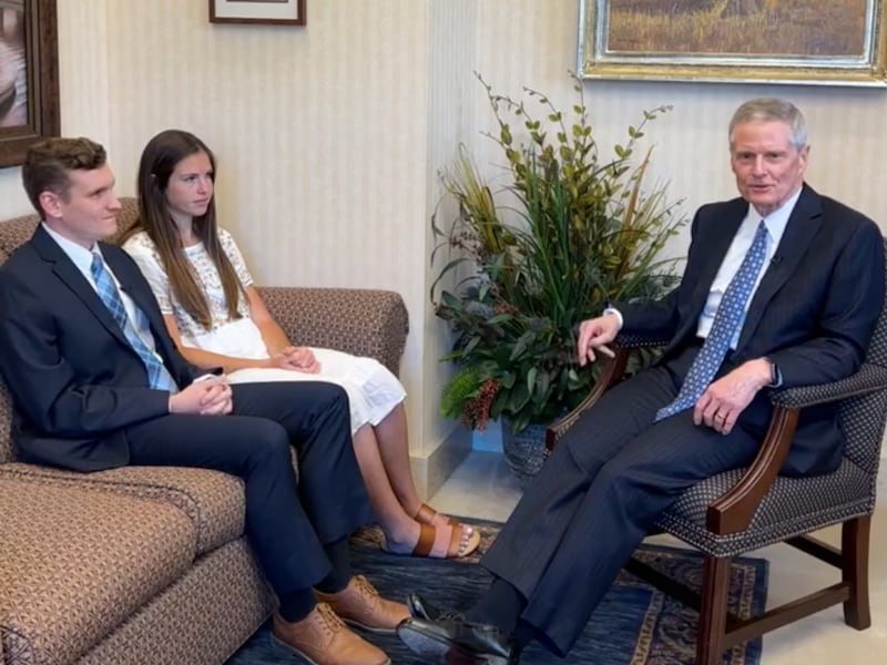 Elder Bednar sitting facing two young adults.