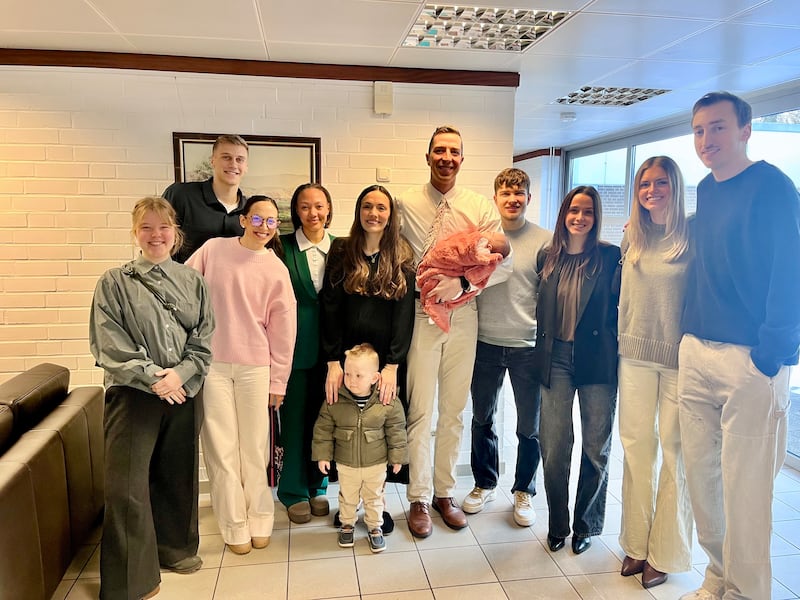 Justin e Claire Bean, no centro, são acompanhados por colegas de equipe e amigos na bênção do bebê de Emery Bean em Berlim, Alemanha, em janeiro de 2026.
