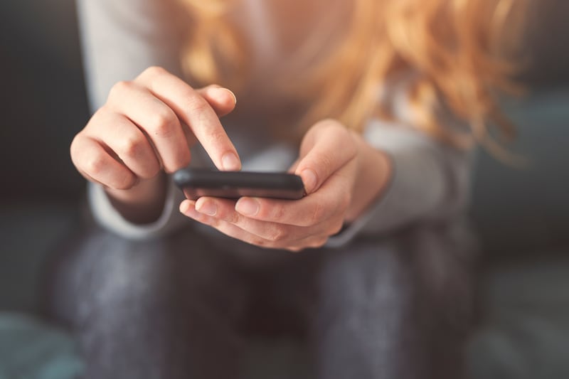Uma jovem mulher olha para seu telefone.