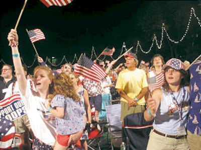 Uma multidão de 600.000 pessoas aplaude a Oquestra Pops de Boston e o Coro do Tabernáculo, cantando músicas sobre a América na celebração do Dia da Independência da nação em Boston, Massachusetts.