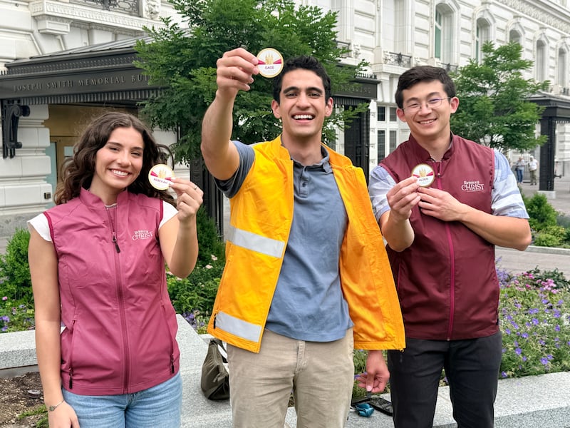 Voluntários exibem seus crachás para a Celebração do Templo de Salt Lake em 2027.