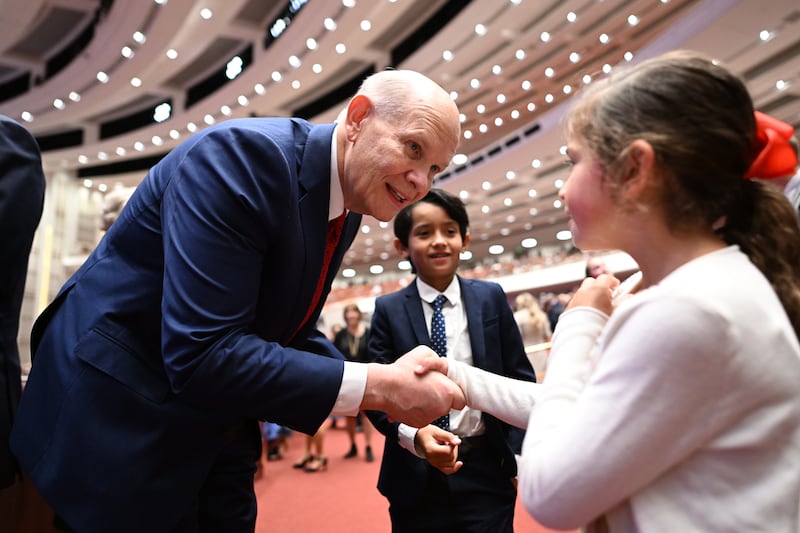 Élder Dale G. Renlund cumprimenta uma criança participando de uma das sessões da conferência geral de outubro de 2022, no Centro de Conferências de Salt Lake City.
