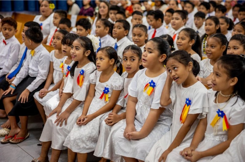 Membros de um coral infantil preparam-se para apresentar-se em uma conferência de estaca especial com o Élder Gary E. Stevenson do Quórum dos Doze Apóstolos de Pago Pago, Samoa Americana, em 24 de maio de 2026.
