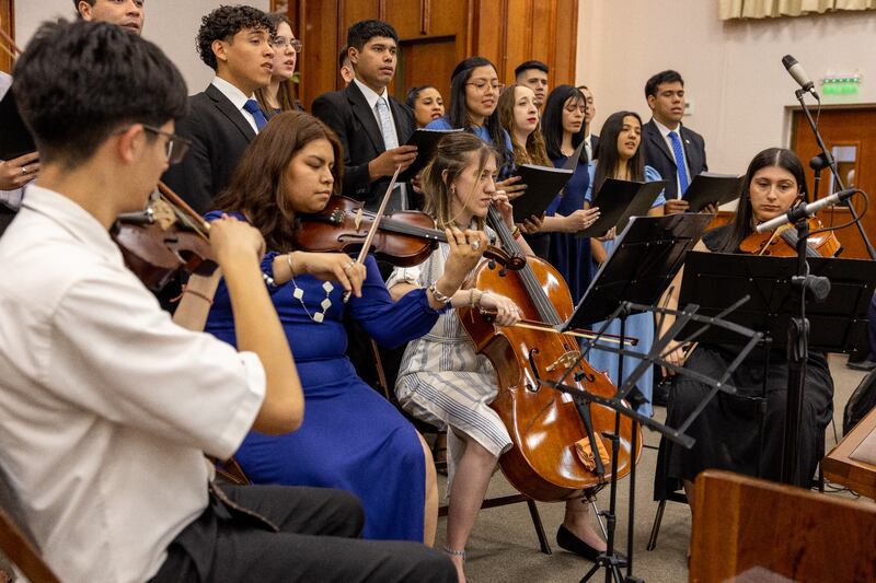 Um coro e orquestra de jovens adultos apresentam-se durante o devocional de Buenos Aires, Argentina, em 11 de novembro de 2025.