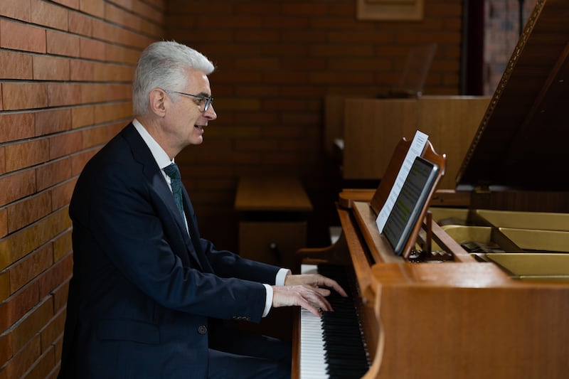 Elder Gérald Caussé do Quórum dos Doze Apóstolos toca piano em 23 de fevereiro de 2026, no Centro de Estaca de Paris, na França, em Versalhes, França, onde serviu como presidente de estaca há mais de 20 anos.