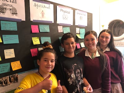 Crianças de uma família em Christchurch, Nova Zelândia, posam para uma foto em frente ao quadro de planejamento da família do programa para Crianças e Jovens na lavanderia de sua casa. As crianças estavam animadas para mostrar à irmã Becky Craven como elas implementaram o novo programa imediatamente após os anúncios sobre o novo programa durante a conferência geral de outubro de 2019. Irmã Craven parou em Christchurch durante uma visita à Área Pacífico com a irmã Sharon Eubank em outubro de 201…