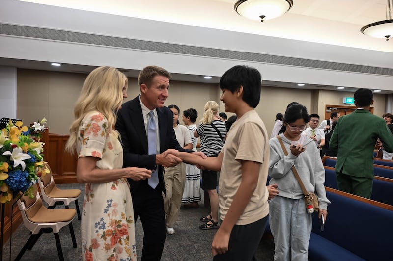 O Presidente Geral dos Rapazes, Timothy L. Farnes, e sua esposa, irmã Linsey Farnes, cumprimentam um jovem depois de o devocional como parte de uma designação ministerial a países da Ásia, de 21 a 31 de maio de 2026.