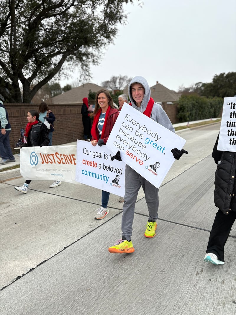 Volunteers walk in the Martin Luther King Jr. Day parade on Saturday Jan. 17, 2025, in Carrollton, Texas.