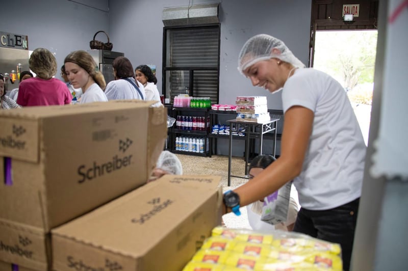 Jovens embalam alimentos durante uma atividade de serviço comunitário de Naguabo, Porto Rico, no sábado, 16 de maio de 2026.