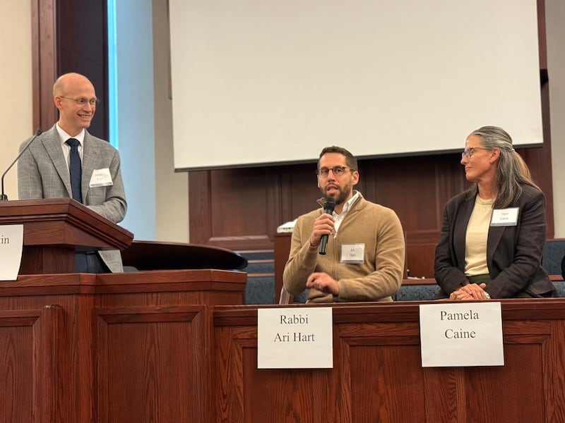 Justin Dyer da BYU, Rabino Ari Hart e Pamela Caine sentam-se na tribuna e dirigem-se ao público durante um encontro interfé em Chicago, Illinois, em 14 de outubro de 2026.