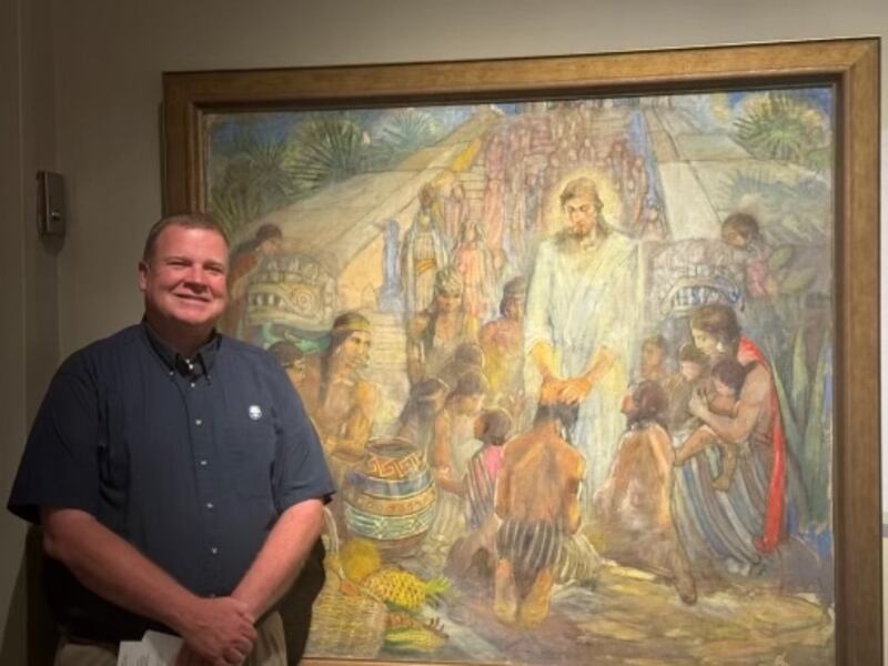 David Anderson stands by "Christ Visits the Nephites" (1956) by Minerva Teichert at the Church History Museum in Salt Lake City