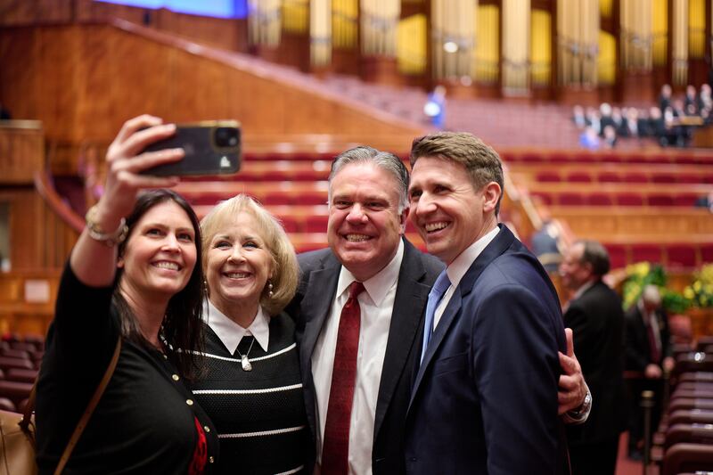 O irmão Bradley S. Wilcox e a irmã Debi Wilcox, no centro, tiram uma selfie após a conferência geral de abril de 2023 no Centro de Conferências.