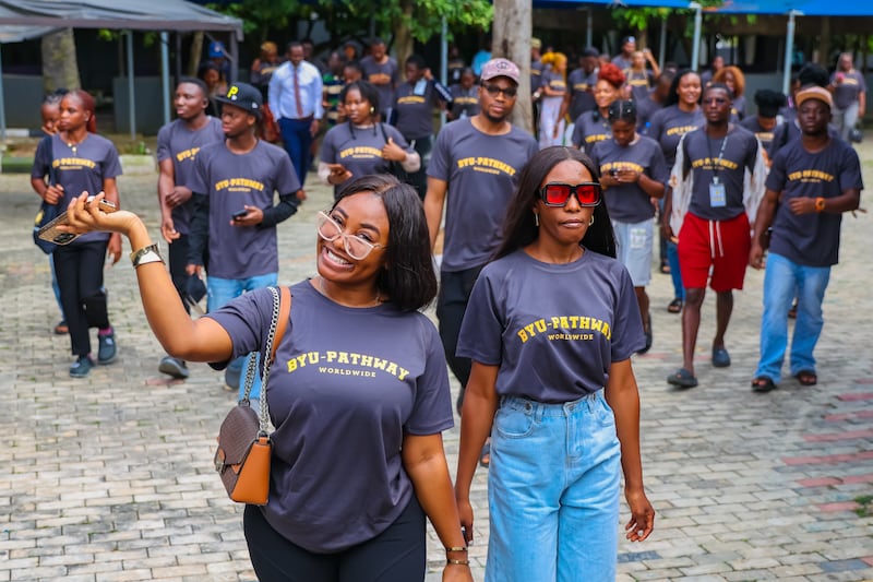 Estudantes de BYU–Pathway Worldwide e outros jovens adultos solteiros e seus amigos se reúnem para um encontro YSA em Lagos, Nigéria, 31 de outubro de 2025.