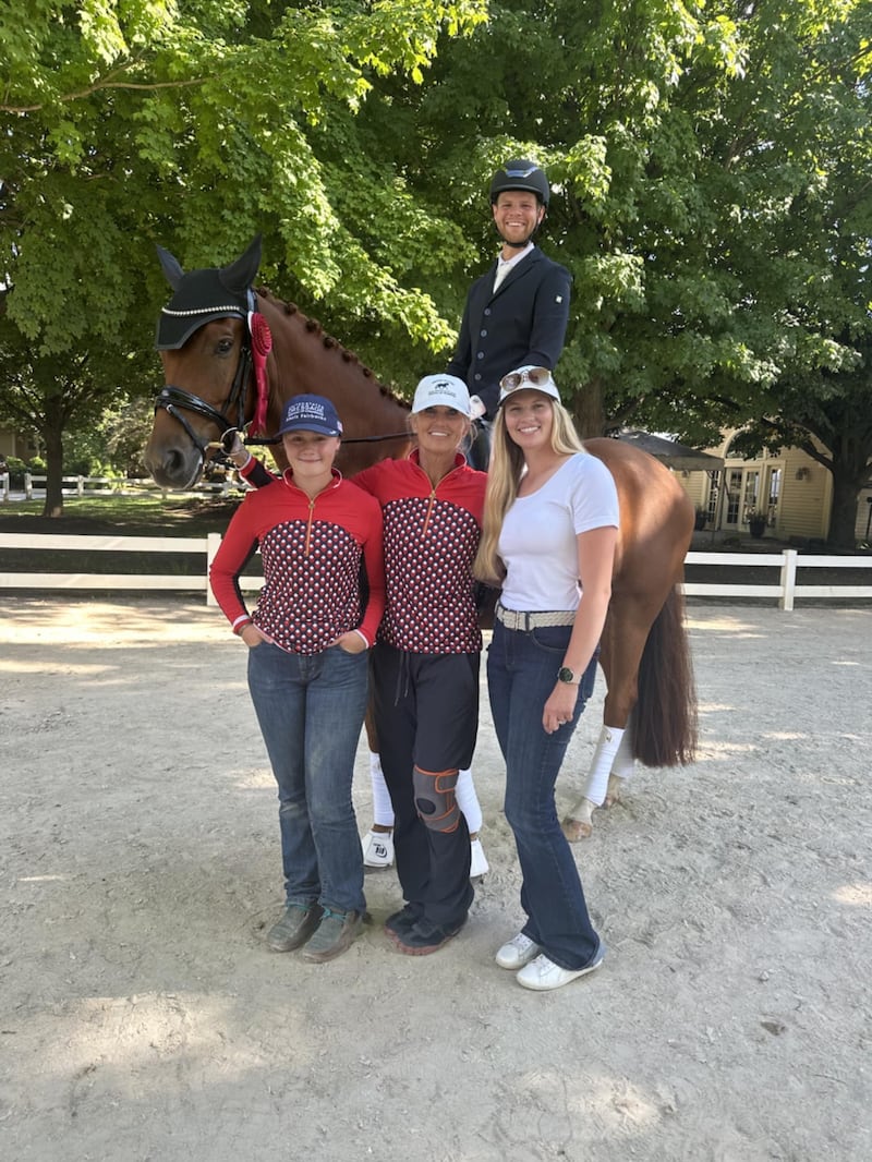 Justin Giles posa para uma foto em Wayne, Illinois, em agosto de 2025 com sua esposa, Samantha Giles, à direita; treinadora, Margo Gogan, ao centro; e colega de equipe, Lexi Fairbanks, à esquerda.