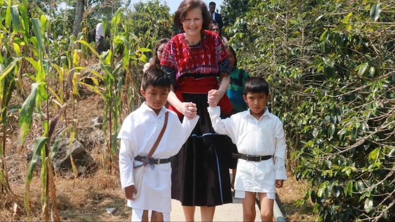 A Presidente Susan H. Porter é conduzida por dois meninos por um campo de milho em Chenalhó, Chiapas, México, em maio de 2026.