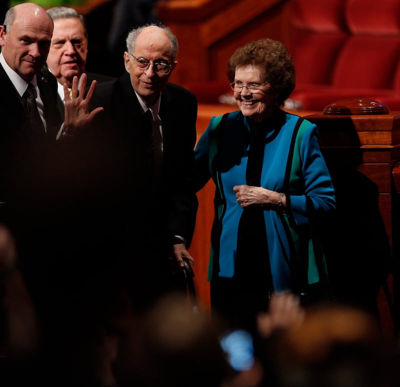 Élder Robert D. Hales, do Quórum dos Doze Apóstolos, saindo com sua esposa, a irmã Mary Hales, da sessão da tarde de domingo da conferência geral de abril de 2015.